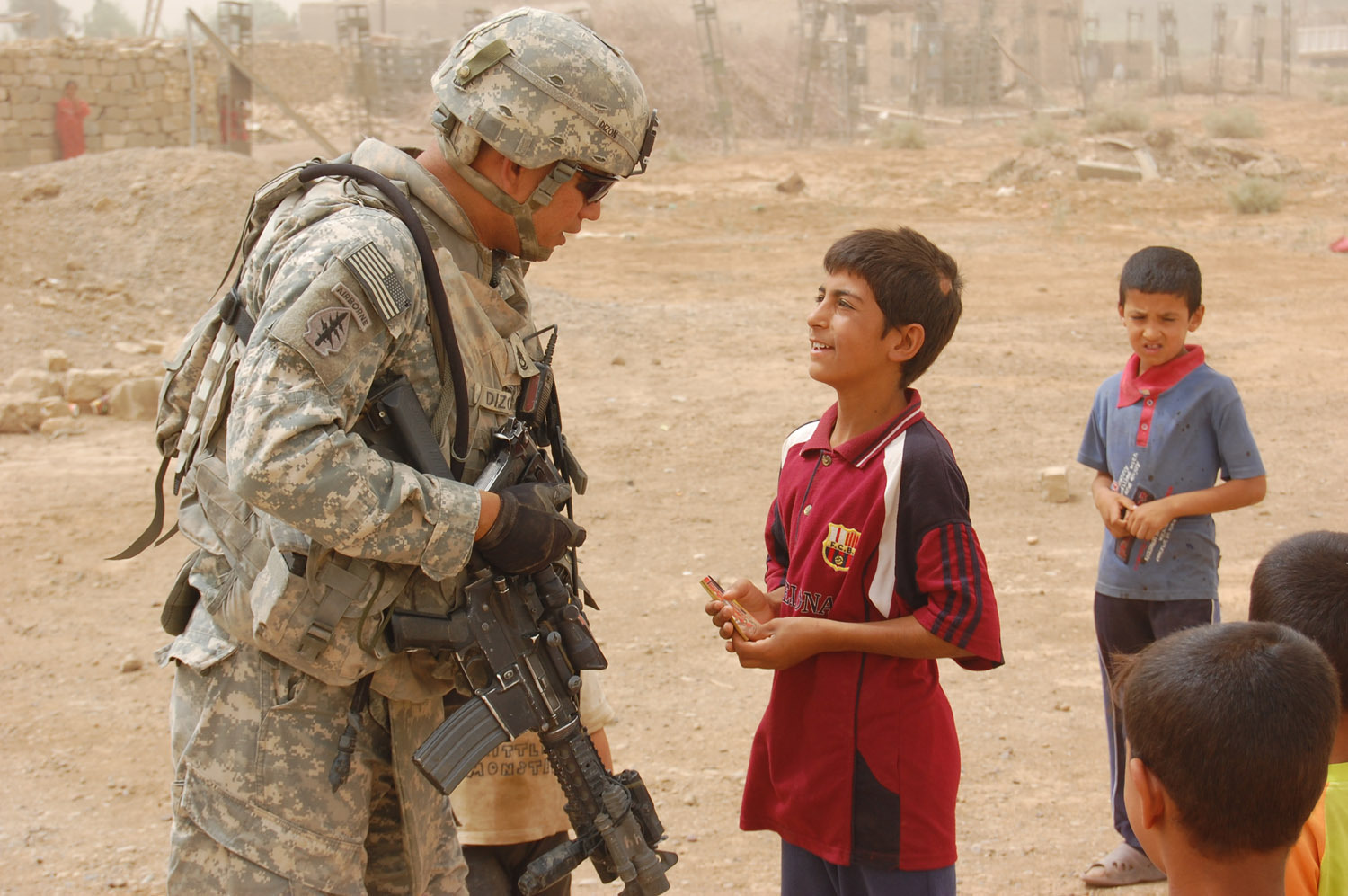 Sgt. 1st Class Carlito Dizon , a San Diego native, listens to a child while on patrol in the Taji Qada, northwest of Baghdad, June 18. Dizon is an infantry platoon sergeant assigned to Company B, 1st Battalion, 27th Infantry Regiment "Wolfhounds," 2nd Stryker Brigade Combat Team, 25th Infantry Division, Multi-National Division: Baghdad.